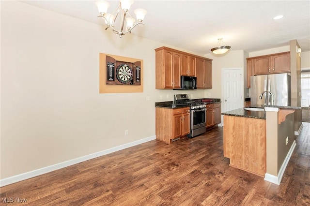 101 Stonegate Cir, Seven Hills, OH 44131 - kitchen featuring appliances with stainless steel finishes, a chandelier, dark wood-style flooring, a breakfast bar area, and dark stone counters