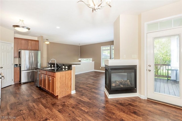 101 Stonegate Cir, Seven Hills, OH 44131 - kitchen featuring stainless steel appliances, dark wood finished floors, a chandelier, and a multi sided fireplace