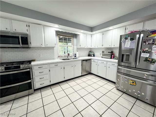 38 Lake Dr, Parkersburg, WV 26104 - kitchen with stainless steel appliances, decorative backsplash, light tile patterned floors, white cabinetry, and recessed lighting