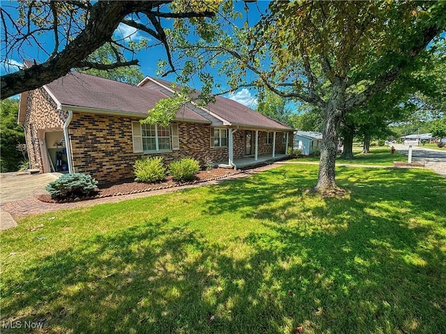 38 Lake Dr, Parkersburg, WV 26104 - single story home with a front yard, brick siding, an attached garage, covered porch, and driveway