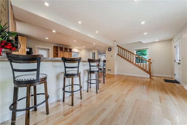 24690 Hawthorne Dr, Euclid, OH 44117 - kitchen with light wood-type flooring, recessed lighting, a breakfast bar, and a peninsula