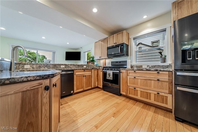 24690 Hawthorne Dr, Euclid, OH 44117 - kitchen with black appliances, light wood finished floors, healthy amount of natural light, dark stone countertops, and recessed lighting