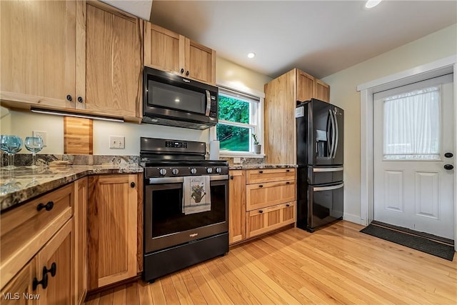 24690 Hawthorne Dr, Euclid, OH 44117 - kitchen featuring black appliances, light wood-style flooring, stone countertops, and recessed lighting