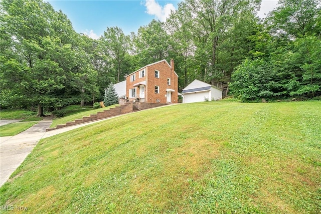24690 Hawthorne Dr, Euclid, OH 44117 - view of property exterior featuring a yard, brick siding, a detached garage, and a chimney