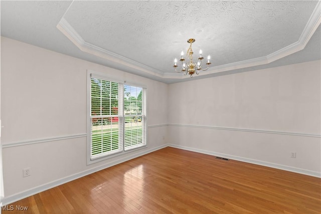 4877 Highland Place Ct, Richmond Heights, OH 44143 - spare room featuring ornamental molding, hardwood / wood-style floors, a chandelier, a textured ceiling, and a raised ceiling