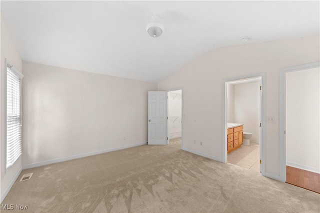 4877 Highland Place Ct, Richmond Heights, OH 44143 - unfurnished bedroom featuring light colored carpet, lofted ceiling, a spacious closet, ensuite bathroom, and a closet