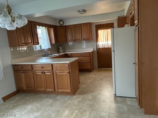 120 Braxton Rd, Weirton, WV 26062 - kitchen with freestanding refrigerator, brown cabinets, light countertops, and backsplash
