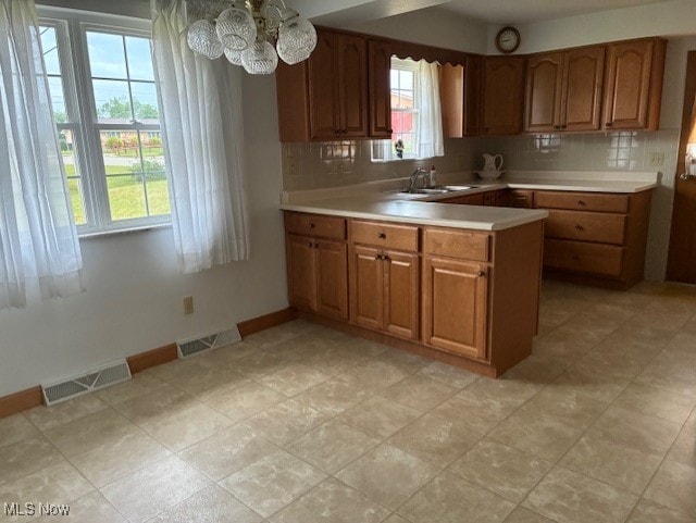 120 Braxton Rd, Weirton, WV 26062 - kitchen featuring brown cabinetry, light countertops, a peninsula, and tasteful backsplash
