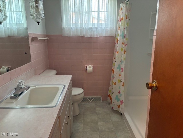 120 Braxton Rd, Weirton, WV 26062 - bathroom with tile walls, vanity, curtained shower, tile patterned flooring, and wainscoting