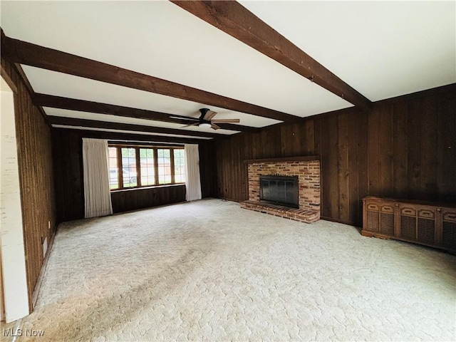 224 N Hills Dr, Parkersburg, WV 26104 - unfurnished living room with wooden walls, beam ceiling, ceiling fan, a fireplace, and carpet flooring