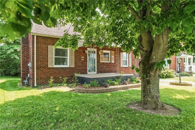 565 12th St, Campbell, OH 44405 - view of property hidden behind natural elements with brick siding, a front lawn, and roof with shingles