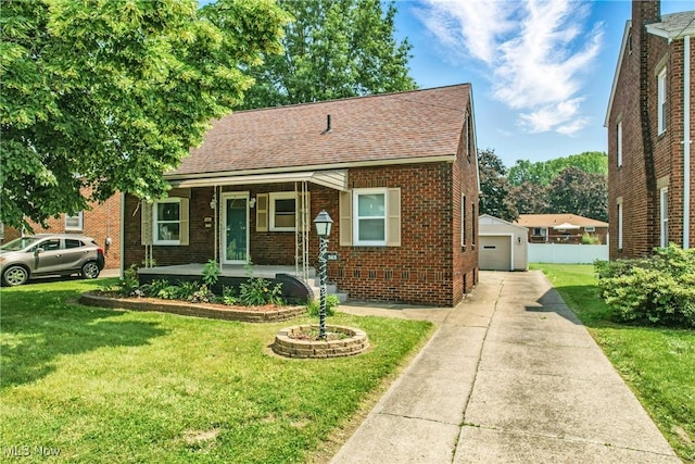 565 12th St, Campbell, OH 44405 - view of front facade featuring covered porch, brick siding, a shingled roof, and an outdoor structure