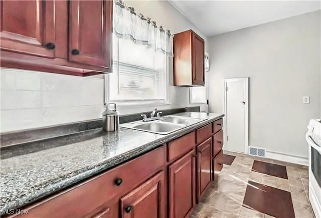 565 12th St, Campbell, OH 44405 - kitchen featuring reddish brown cabinets and tasteful backsplash