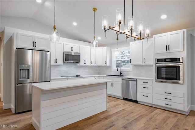 1404 15th St, Vienna, WV 26105 - kitchen with stainless steel appliances, lofted ceiling, a chandelier, a kitchen island, and tasteful backsplash