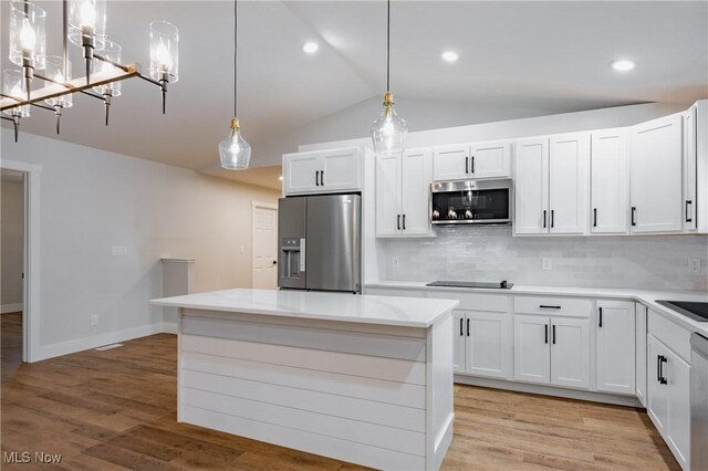 1404 15th St, Vienna, WV 26105 - kitchen featuring stainless steel appliances, backsplash, vaulted ceiling, white cabinetry, and a chandelier
