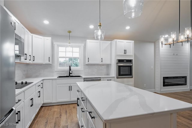 1404 15th St, Vienna, WV 26105 - kitchen featuring appliances with stainless steel finishes, light wood finished floors, tasteful backsplash, light countertops, and white cabinets