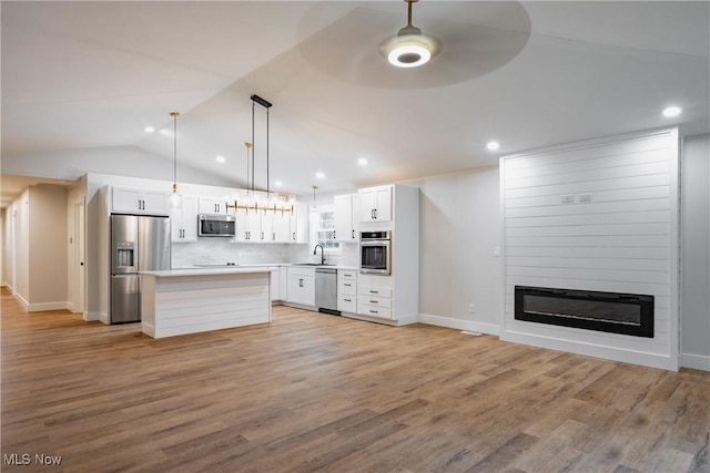 1404 15th St, Vienna, WV 26105 - kitchen featuring stainless steel appliances, a large fireplace, white cabinets, ceiling fan, and a kitchen island