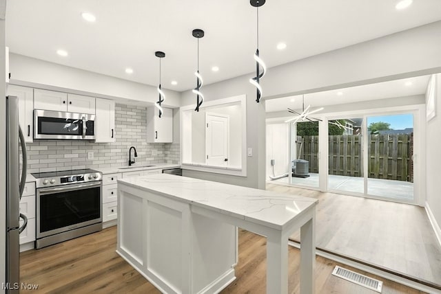 5830 Spotswood Dr, Lyndhurst, OH 44124 - kitchen featuring stainless steel appliances, white cabinets, tasteful backsplash, light stone counters, and recessed lighting