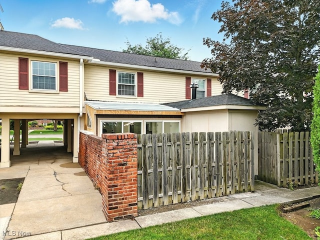 5830 Spotswood Dr, Lyndhurst, OH 44124 - view of front facade featuring a carport, brick siding, and roof with shingles
