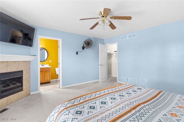 313 Crimson Cir, Campbell, OH 44405 - carpeted bedroom with a tiled fireplace, a ceiling fan, a spacious closet, connected bathroom, and a closet