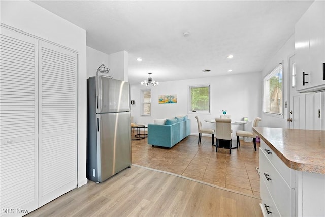 929 Moneta Ave, Aurora, OH 44202 - kitchen with freestanding refrigerator, white cabinets, a chandelier, and recessed lighting