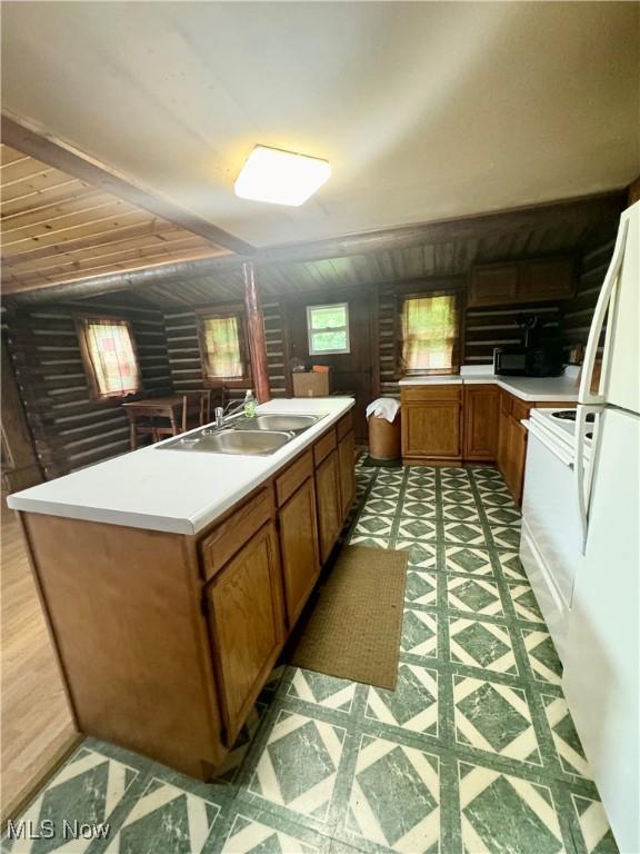 1917 Township Road 26, Killbuck, OH 44637 - kitchen featuring brown cabinetry, light countertops, light flooring, stove, and wooden walls