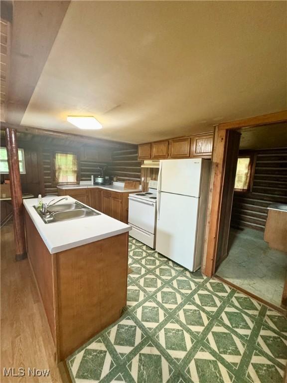 1917 Township Road 26, Killbuck, OH 44637 - kitchen featuring white appliances, light countertops, brown cabinets, and a peninsula