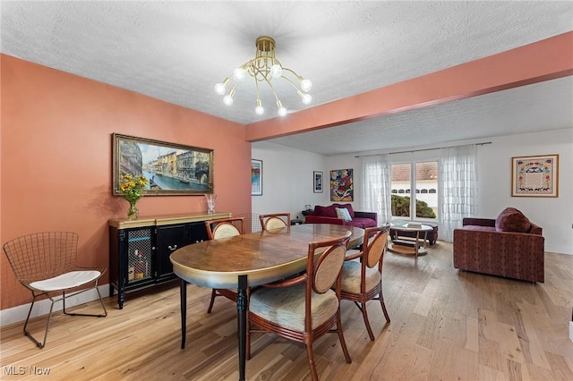 2632 S Green Rd, University Heights, OH 44122 - dining room featuring a chandelier, light wood finished floors, and a textured ceiling