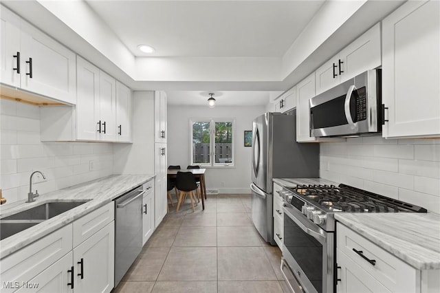 2632 S Green Rd, University Heights, OH 44122 - kitchen with stainless steel appliances, white cabinetry, light tile patterned floors, a tray ceiling, and recessed lighting
