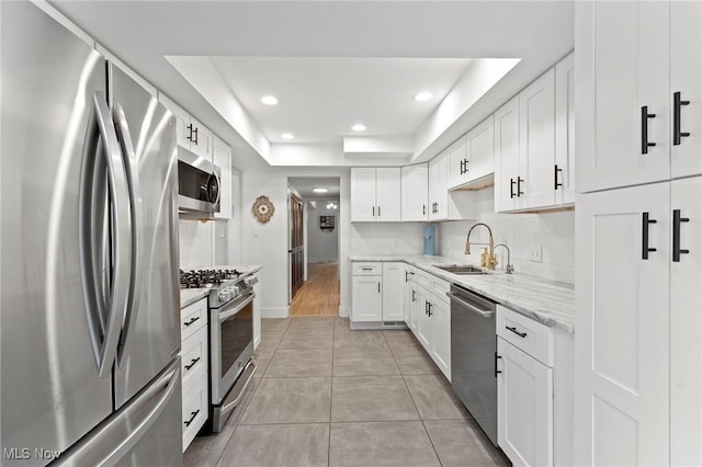 2632 S Green Rd, University Heights, OH 44122 - kitchen featuring appliances with stainless steel finishes, a raised ceiling, white cabinetry, recessed lighting, and light stone counters