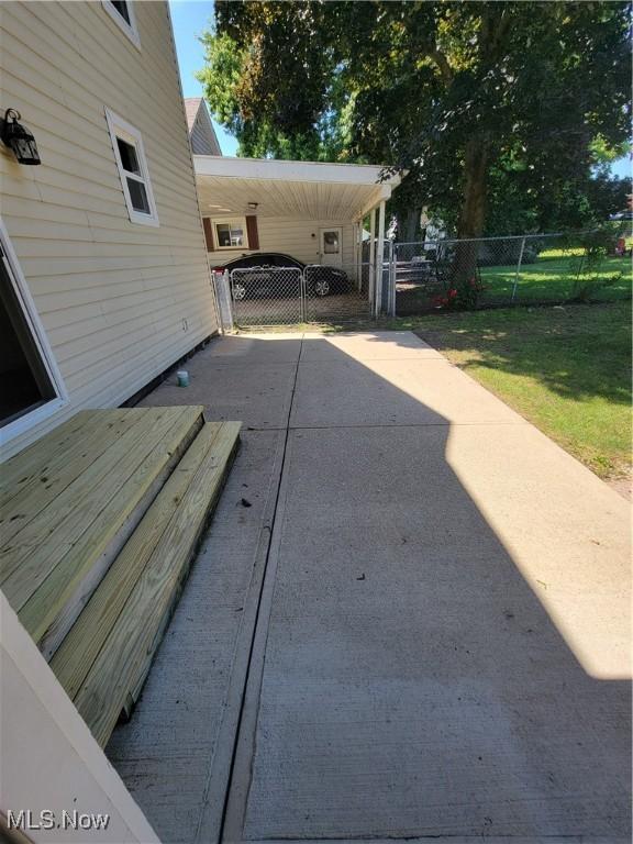 262 High St, Conneaut, OH 44030 - view of patio featuring driveway, an attached carport, and a gate