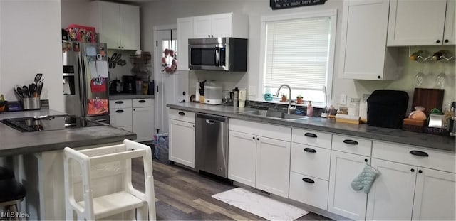 29928 Buck Rd, Salem, OH 44460 - kitchen with stainless steel appliances, white cabinets, dark countertops, dark wood finished floors, and a breakfast bar area