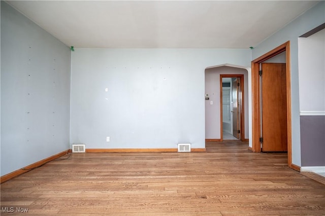 135 Renee Dr, Struthers, OH 44471 - spare room featuring arched walkways and wood finished floors