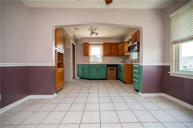 135 Renee Dr, Struthers, OH 44471 - kitchen featuring green cabinets, stainless steel microwave, light countertops, light tile patterned flooring, and arched walkways