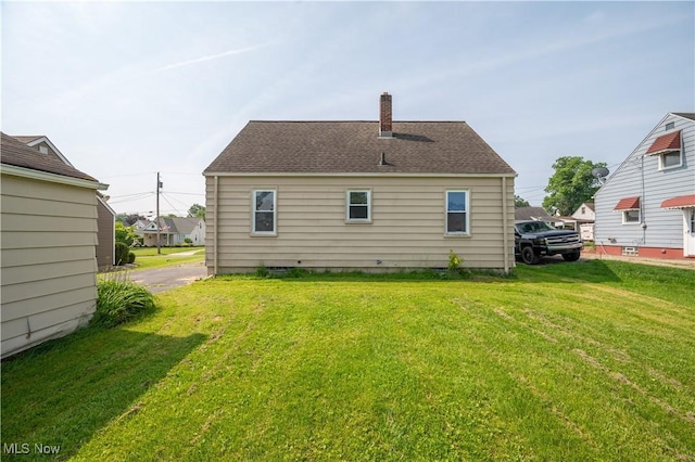 135 Renee Dr, Struthers, OH 44471 - back of house featuring a lawn and a chimney