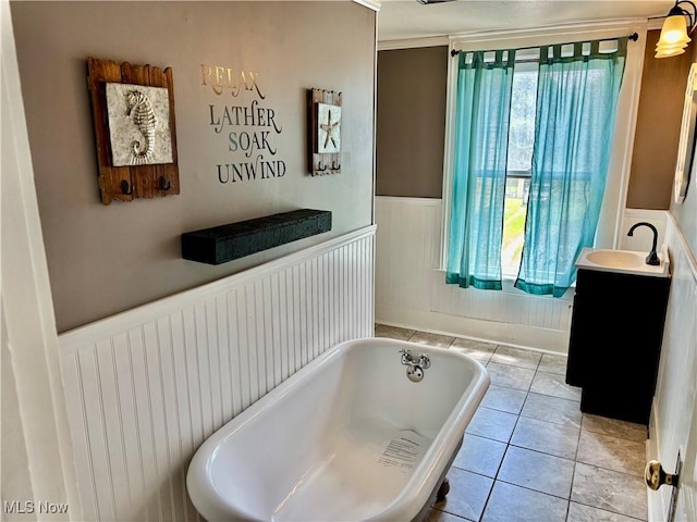 391 Cornell St, Akron, OH 44310 - full bath with a freestanding tub, vanity, wainscoting, tile patterned flooring, and radiator heating unit