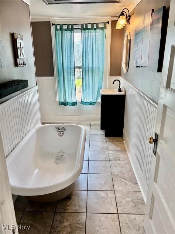 391 Cornell St, Akron, OH 44310 - bathroom featuring a freestanding tub, vanity, wainscoting, and tile patterned floors