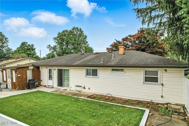 4477 S Warwick Dr, Canfield, OH 44406 - rear view of house with a patio area, a yard, a chimney, an outbuilding, and roof with shingles