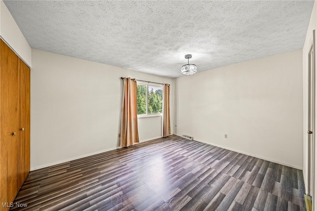 5523 Weston Ct Unit 88A, Willoughby, OH 44094 - unfurnished bedroom featuring dark wood-style floors, a closet, a textured ceiling, and a chandelier