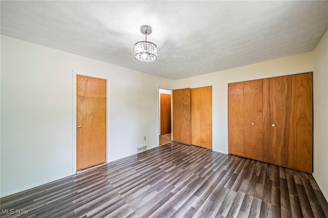 5523 Weston Ct Unit 88A, Willoughby, OH 44094 - unfurnished bedroom featuring wood finished floors, multiple closets, a chandelier, and a textured ceiling