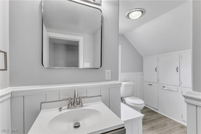 13050 Diagonal Rd, Salem, OH 44460 - bathroom with lofted ceiling, a wainscoted wall, vanity, a decorative wall, and wood finished floors
