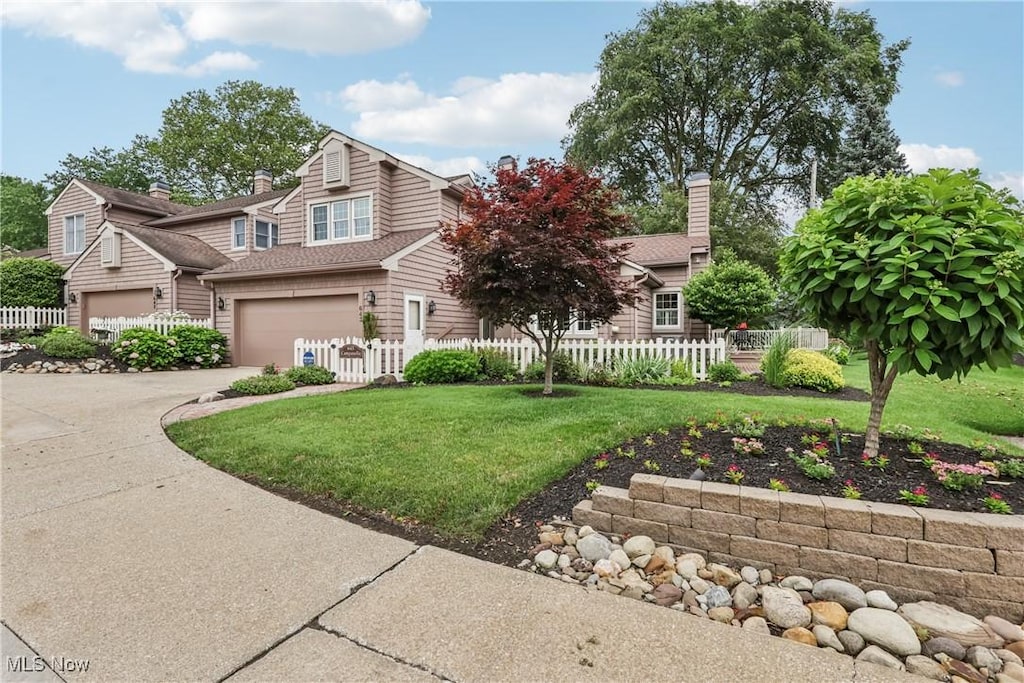 643 Isle View Dr, Akron, OH 44319 - view of front of house featuring concrete driveway, a garage, and a chimney