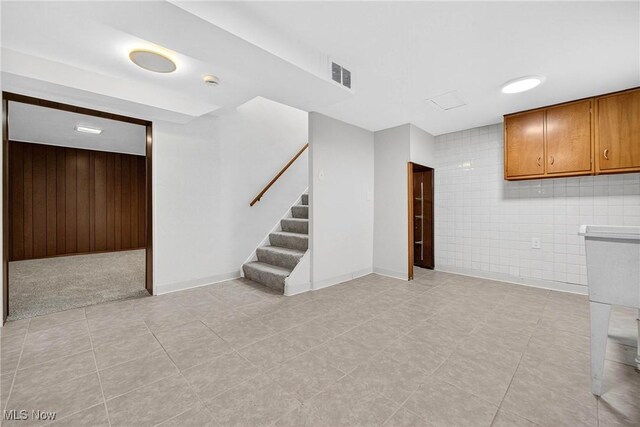 738 Sterling Rd, Wickliffe, OH 44092 - finished below grade area with stairway, wood walls, tile walls, and light tile patterned flooring