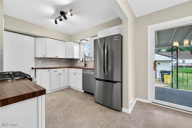 738 Sterling Rd, Wickliffe, OH 44092 - kitchen featuring appliances with stainless steel finishes, wood counters, tasteful backsplash, and white cabinetry