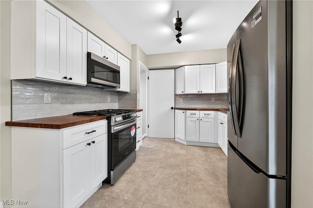 738 Sterling Rd, Wickliffe, OH 44092 - kitchen with stainless steel appliances, butcher block counters, backsplash, and white cabinetry