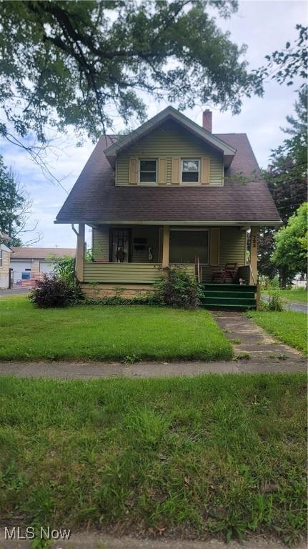 722 5th St, Struthers, OH 44471 - view of front of house with a chimney, a porch, and a front lawn
