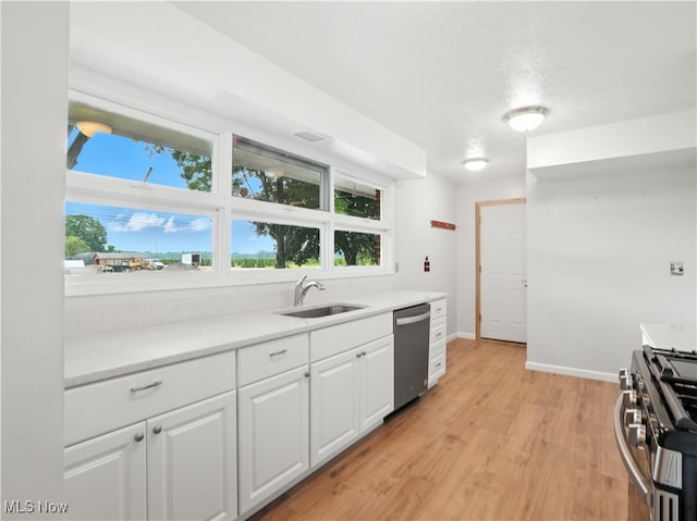 4833 Middle Ridge Rd, Perry, OH 44081 - kitchen with appliances with stainless steel finishes, white cabinets, light countertops, light wood-style flooring, and plenty of natural light