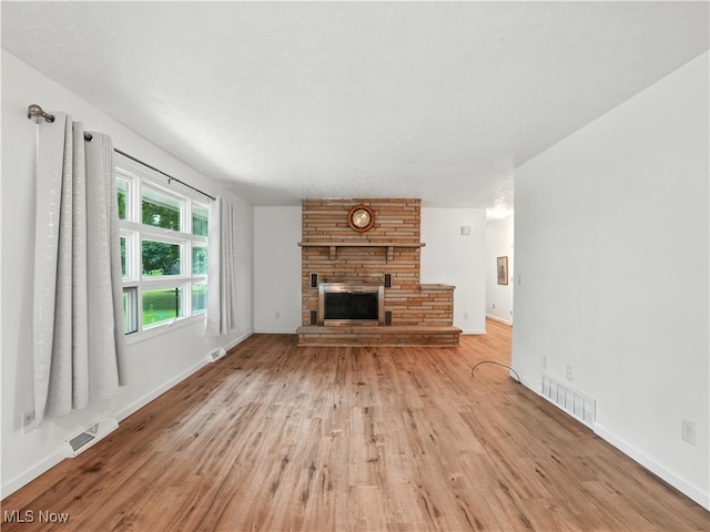 4833 Middle Ridge Rd, Perry, OH 44081 - unfurnished living room featuring light wood-style flooring and a fireplace