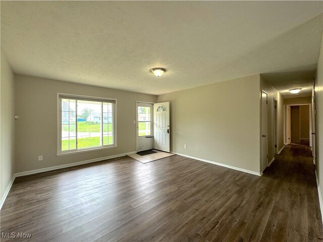 24525 Sherborne Rd, Bedford Heights, OH 44146 - empty room with dark wood-style flooring and a textured ceiling