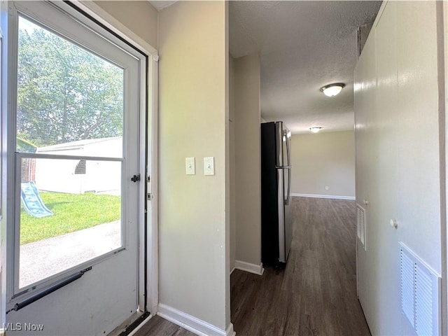 24525 Sherborne Rd, Bedford Heights, OH 44146 - doorway to outside with dark wood finished floors, plenty of natural light, and a textured ceiling